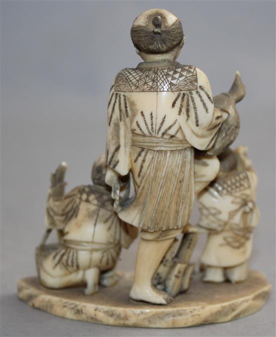 A Japanese carved ivory okimono group of street vendors, Meiji period,(-)